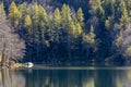 A lone fisherman on Lake Santo Modenese, Italy, catches a fish that jumps out of the water Royalty Free Stock Photo