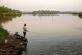 lone fisherman using a fishing rod in a river