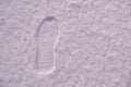 Lone footprint in the snow in winter. Imprint of shoes in the snow