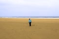 Lone girl walking a beach against the cold wind Royalty Free Stock Photo