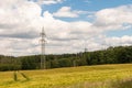 A lone high-voltage tower in a yellow wheat field. European summer landscape photo Royalty Free Stock Photo