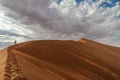 Lone hiker ascending Big Daddy dune in Namibia Royalty Free Stock Photo