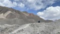 A lone hiker walks along a mountain path. View of the mountains, colored rocks and hills of Kyrgyzstan. Beautiful mountain