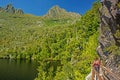 Hiker on board walkway at side of Dove Lake with Cradle Mountain`s peaks in the background at Tasmania, Australia. Royalty Free Stock Photo