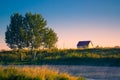 Lone house with tree on banks of river on a summer morning with mist Royalty Free Stock Photo
