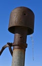 Icicle hangs from an old tractor muffler