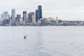A lone kayaker paddles toward the Seattle skyline.