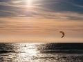 Lone kite surfer surfing at sunset