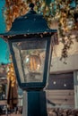 a lone lantern with a lamp, which from time to time has been braided by a cobweb