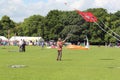 Lone man flying large kite.
