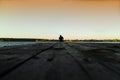 Lone man on pier orange sunset
