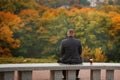 Lone man sitting on the stone bench and looking at nature. Back Royalty Free Stock Photo