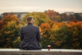 Lone man sitting on the stone bench and looking at nature. Back view. Royalty Free Stock Photo