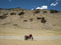 Lone motorbike, motorcycle on adventurous road through besides river and mountains with clear blue sky on Manali to Leh highway in