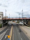 A lone motorbike zips beneath the bridge, a solitary figure against the urban architecture