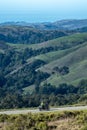 Lone motorcycle riding along a mountain ridge with green hills in the background Royalty Free Stock Photo