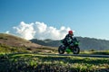 Lone motorcycle riding along a mountain ridge with spectacular landscape and clouds Royalty Free Stock Photo