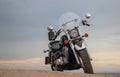 Off-road motorcycle standing still in the open desert beneath heavy clouds Royalty Free Stock Photo