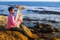 Lone musician playing the Tuba on the ocean coast. Royalty Free Stock Photo