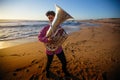 Lone musician playing the Tuba on the ocean coast. Royalty Free Stock Photo