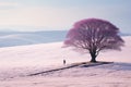 a lone person standing in front of a pink tree in the middle of a snowy field Royalty Free Stock Photo