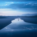 a lone person standing in the middle of a lake