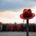 Lone red hat atop pole, sharply contrasts with blurred surroundings