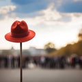 Lone red hat atop pole, sharply contrasts with blurred surroundings