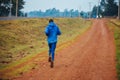 A lone runner trains in Kenya. A marathon runner runs on red soil in the city of Iten, home of Champions. Motivation to run, Royalty Free Stock Photo