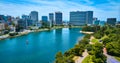 Lone sailboat on Lake Merritt with aerial of downtown Oakland buildings in California