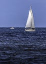 Lone Sailboat And Power Boat Cruising The Coast Royalty Free Stock Photo