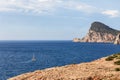 Lone sailing yacht rushes along small bay Galera waves to proudly rising to the sky cape Cap Nuno Nono, Ibiza, Balearic Islands