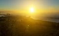 A lone silhouette of a cyclist riding in strong fog along the river bank in a city park early in the morning. Rays of Royalty Free Stock Photo