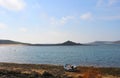A lone boat waits on the weedy shore by the empty waters off Tresco island in the Isles of Scilly England.