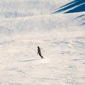Lone snowboarder riding down a steep slope at an alpine sports resort