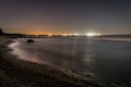 A solitary rock in a flat sea at night Royalty Free Stock Photo