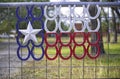 Lone Star Texas flag created with red, white, & blue horsehoes on gated fence.