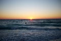 Lone surfer on the waves at sunset