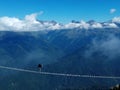 a lone thrill-seeker on the suspension bridge in the mountains Royalty Free Stock Photo