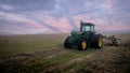 Lone tractor in the morning in a big field.