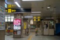 A lone train station master standing inside a booth in an Osaka metro train station