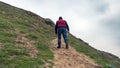 A lone traveler climbs a mountain peak