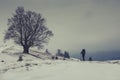 Lone traveler walking along the road in the mountains. Winter landscape. Royalty Free Stock Photo