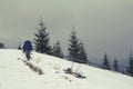 Lone traveler walking along the road in the mountains. Winter landscape. Royalty Free Stock Photo