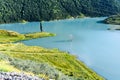 A lone tree sticks out of the water in the Zaramag reservoir. Mountains of the North Caucasus. Hot summer day. Republic of North