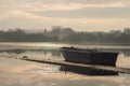 A lone unmanned boat sits idle on a frozen lake during sunrise on Hornsea Mere Royalty Free Stock Photo