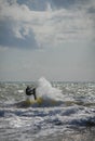 Lone unrecognizable kiter in the stormy sea on the beach of Marina di San Nicola in Italy
