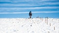 Lone walker climbs on top of white snow ridge. Hillwalking in winter conditions Royalty Free Stock Photo