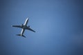 Lone white airplaine flying in the sky on a clear blue day