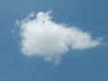a lone white cloud in a clear blue sky